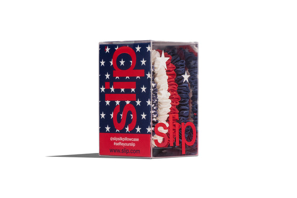 Box of red, white and blue hair ties in a slip® branded box on a white background