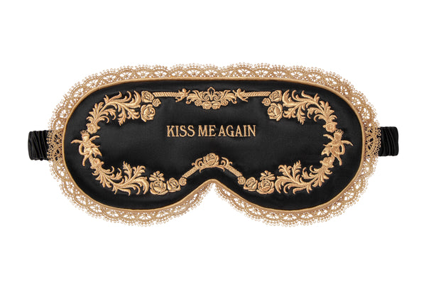 Black contour sleep mask with gold lace design and 'Kiss Me Again' embroidery on a white background