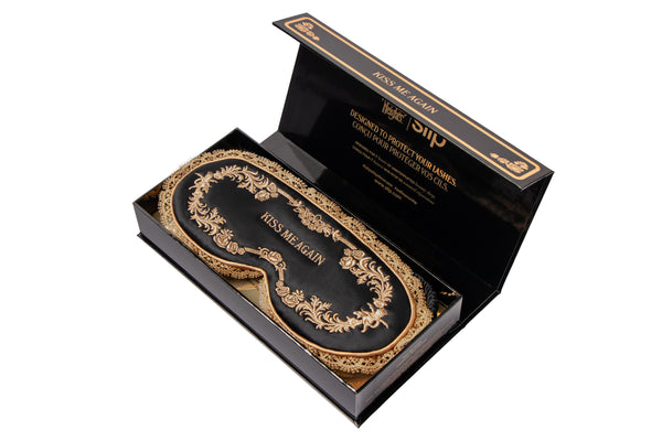 Decorative black and gold contour sleep mask packaging on a white background