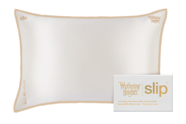White pillow with gold trim and 'Wuthering Heights' embroidery + packaging on a white background