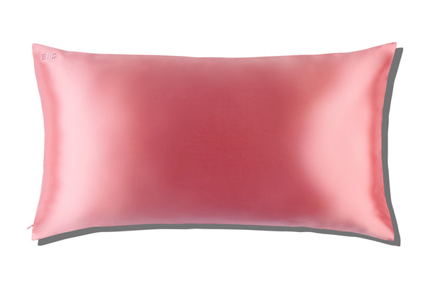 A blush pink queen-sized pillowcase with a zipper, displayed alongside its packaging box with the brand 'slip' visible.