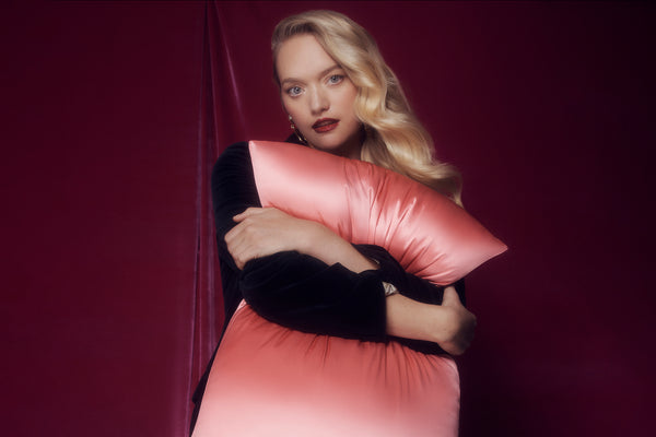 Blush pink silk pillowcase in slip packaging on a white background.