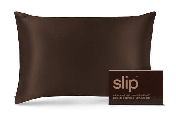 A dark brown slip silk pillowcase shown next to its matching dark brown packaging box with the brand name 'slip' printed in gold.